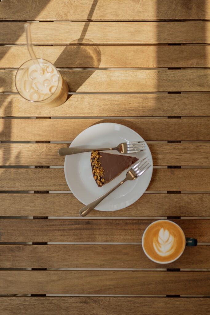 A piece of pie on a plate next to a cup of coffee